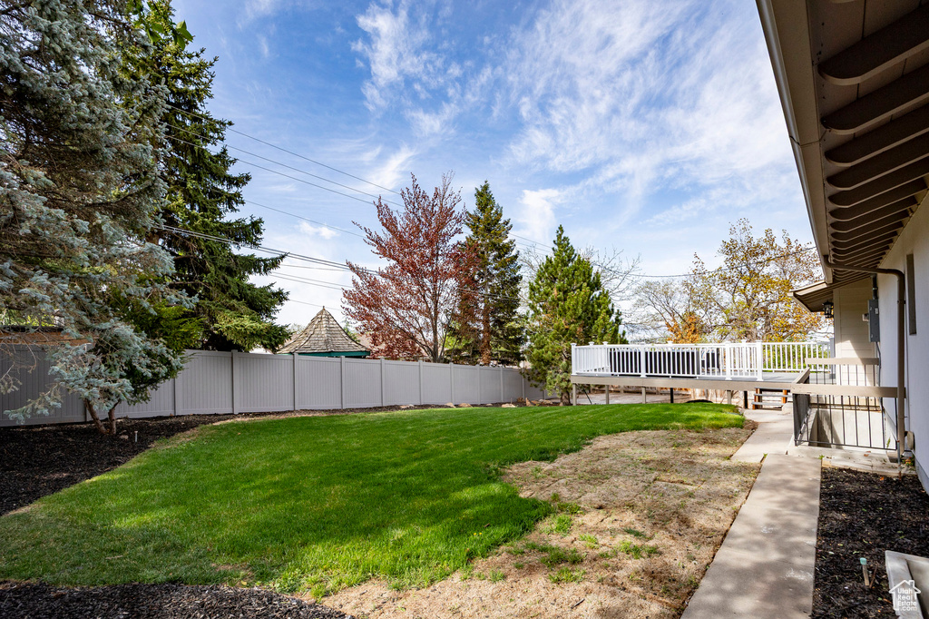 View of yard featuring fence and a deck
