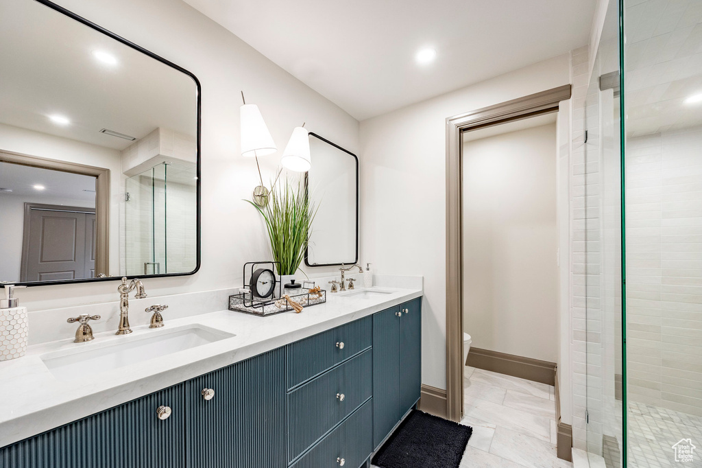 Bathroom featuring a sink, a stall shower, and toilet