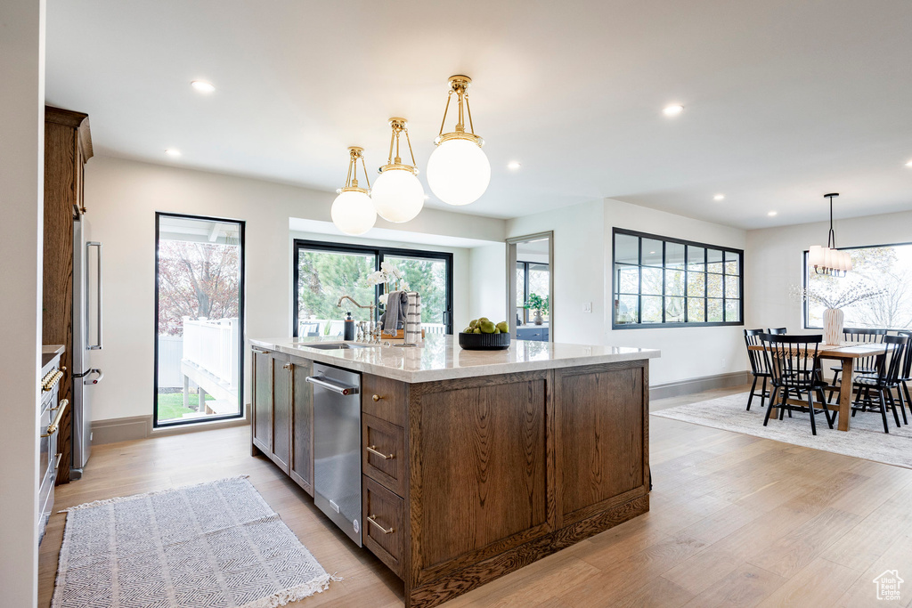 Kitchen with recessed lighting, light wood finished floors, a kitchen island with sink, and stainless steel appliances