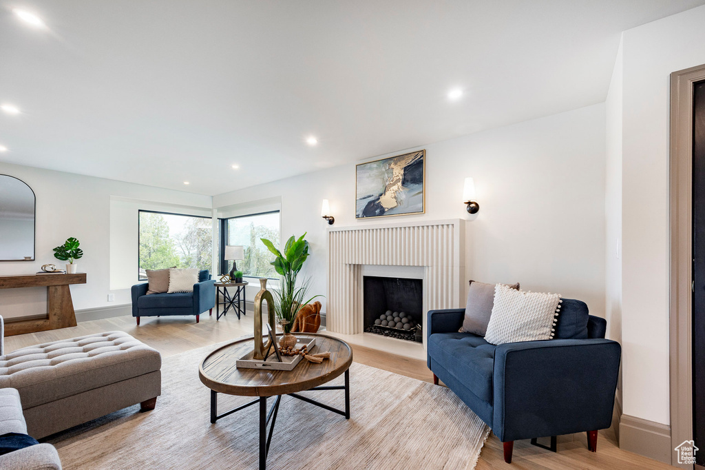 Living area featuring recessed lighting, light wood finished floors, baseboards, and a fireplace