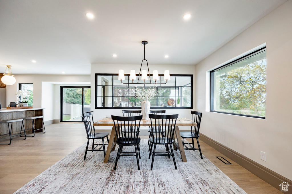 Dining area featuring visible vents, wood finished floors, baseboards, recessed lighting, and a chandelier