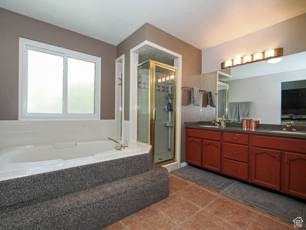 Bathroom with a sink, a garden tub, a stall shower, and double vanity