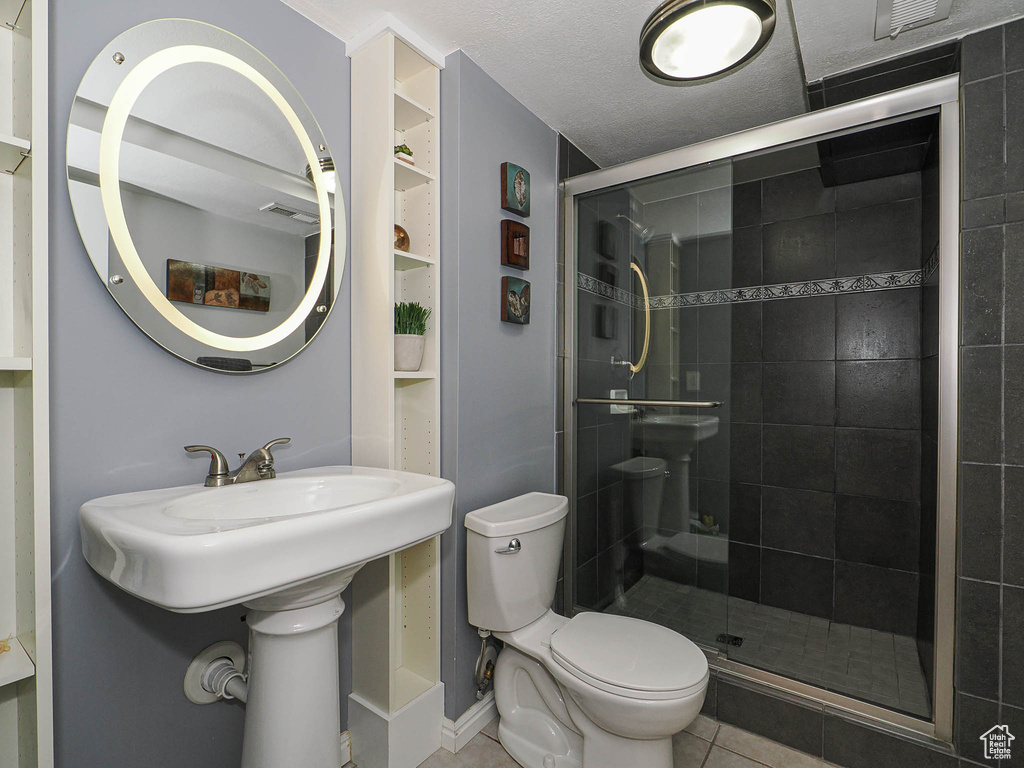 Full bathroom with visible vents, toilet, tile patterned floors, a sink, and a stall shower
