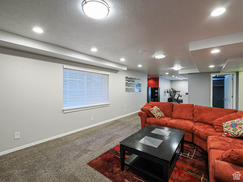 Living area with baseboards, carpet, recessed lighting, and a textured ceiling