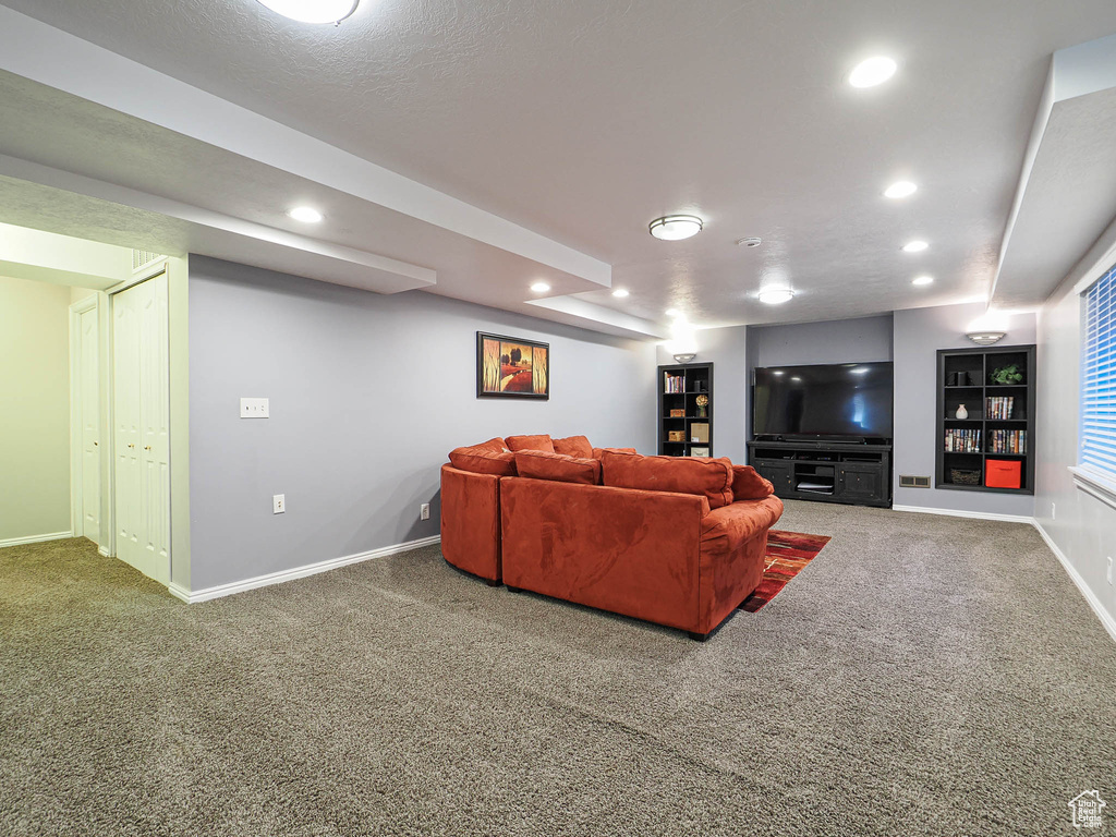 Carpeted living room featuring baseboards, recessed lighting, and visible vents