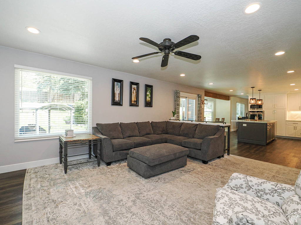 Living room featuring baseboards, recessed lighting, dark wood finished floors, and a ceiling fan