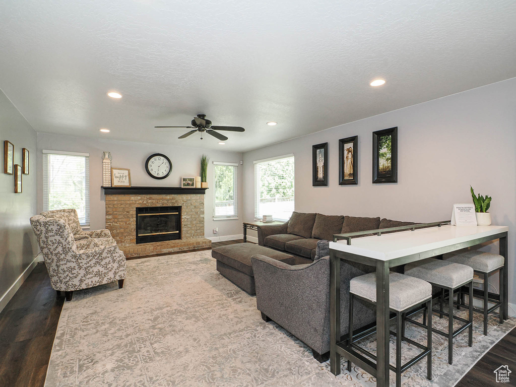 Living area with recessed lighting, baseboards, a glass covered fireplace, and wood finished floors