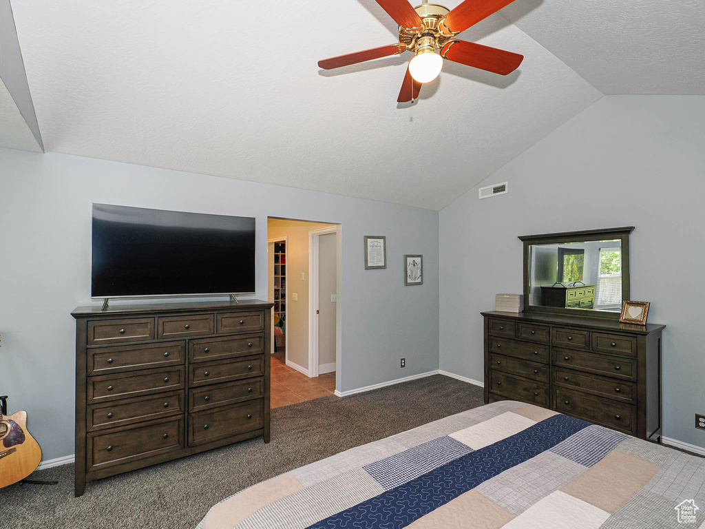 Bedroom with carpet floors, a ceiling fan, baseboards, lofted ceiling, and visible vents