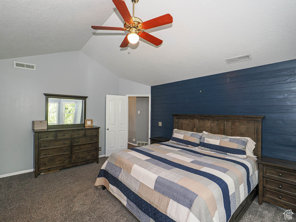 Bedroom featuring visible vents, carpet floors, and lofted ceiling