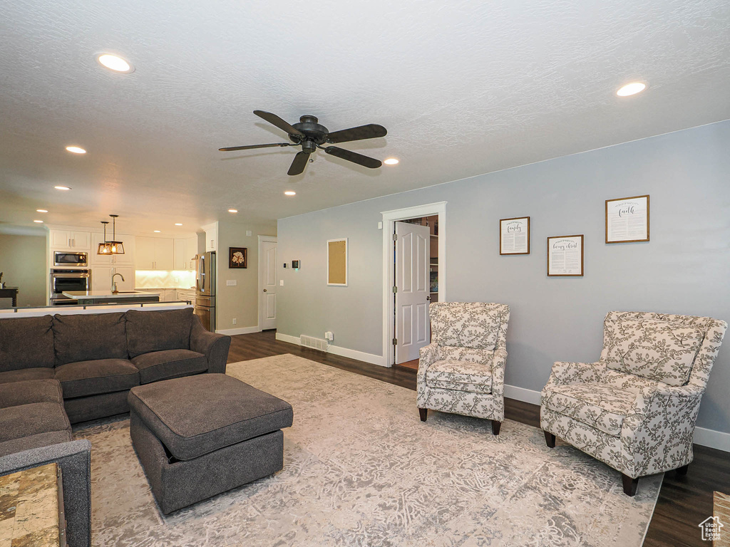 Living room with recessed lighting, a ceiling fan, and wood finished floors