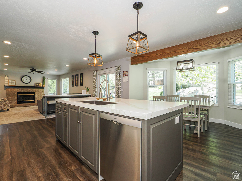 Kitchen with stainless steel dishwasher, open floor plan, recessed lighting, gray cabinets, and a sink