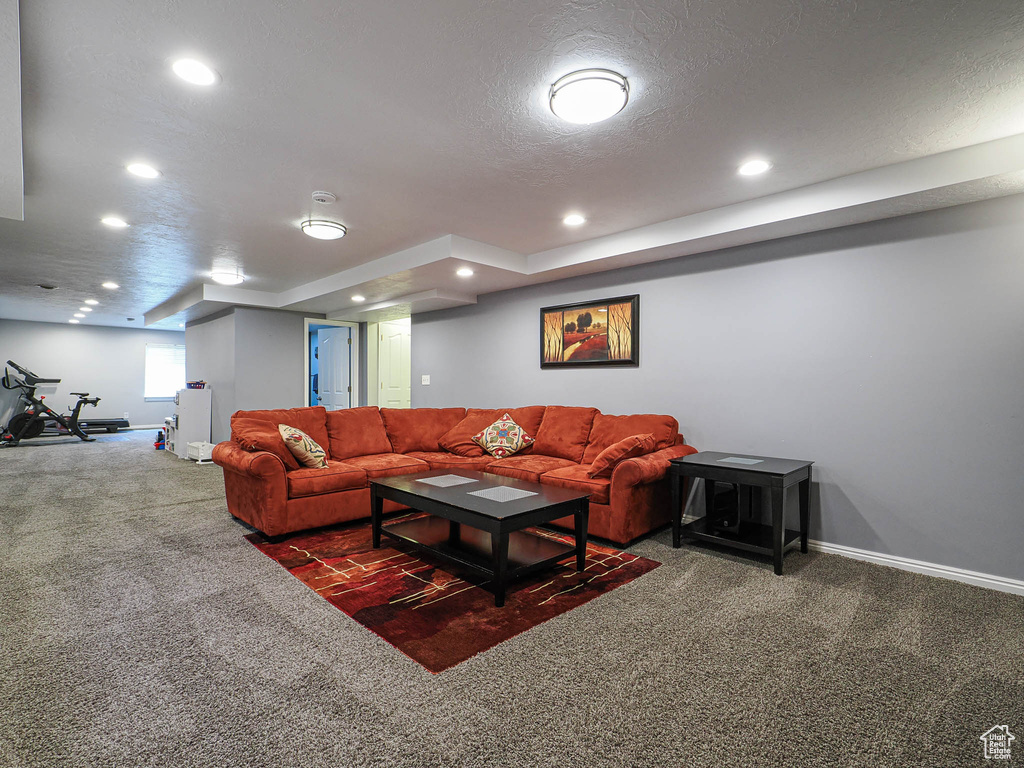 Carpeted living area with recessed lighting, baseboards, and a textured ceiling