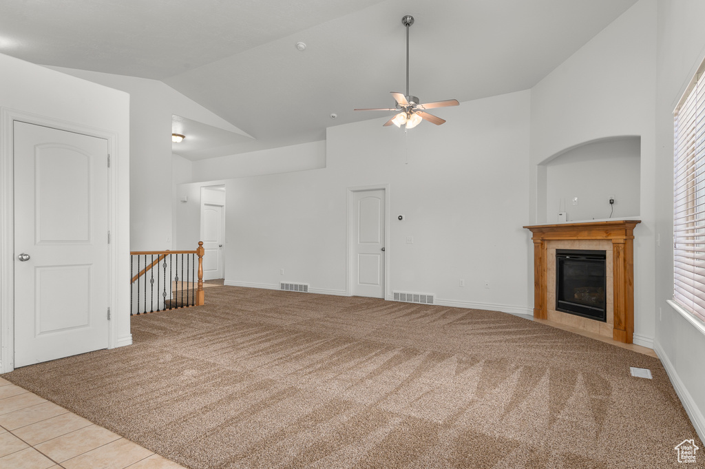Unfurnished living room with carpet, a ceiling fan, a tile fireplace, and visible vents