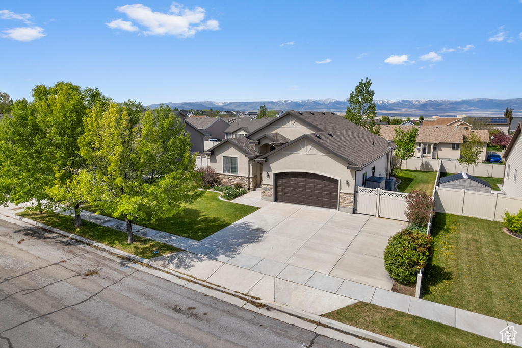 Ranch-style home featuring fence, an attached garage, a front lawn, stucco siding, and concrete driveway
