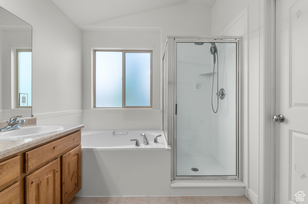 Full bathroom featuring vanity, a garden tub, tile patterned floors, a shower stall, and vaulted ceiling