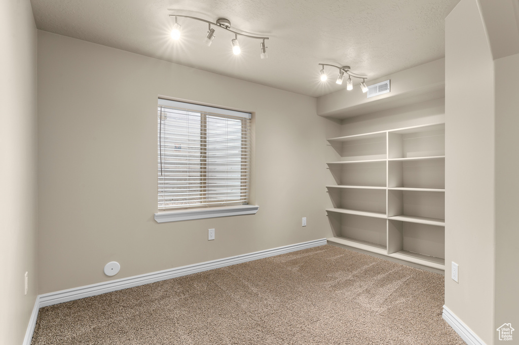 Unfurnished room featuring visible vents, carpet flooring, and baseboards