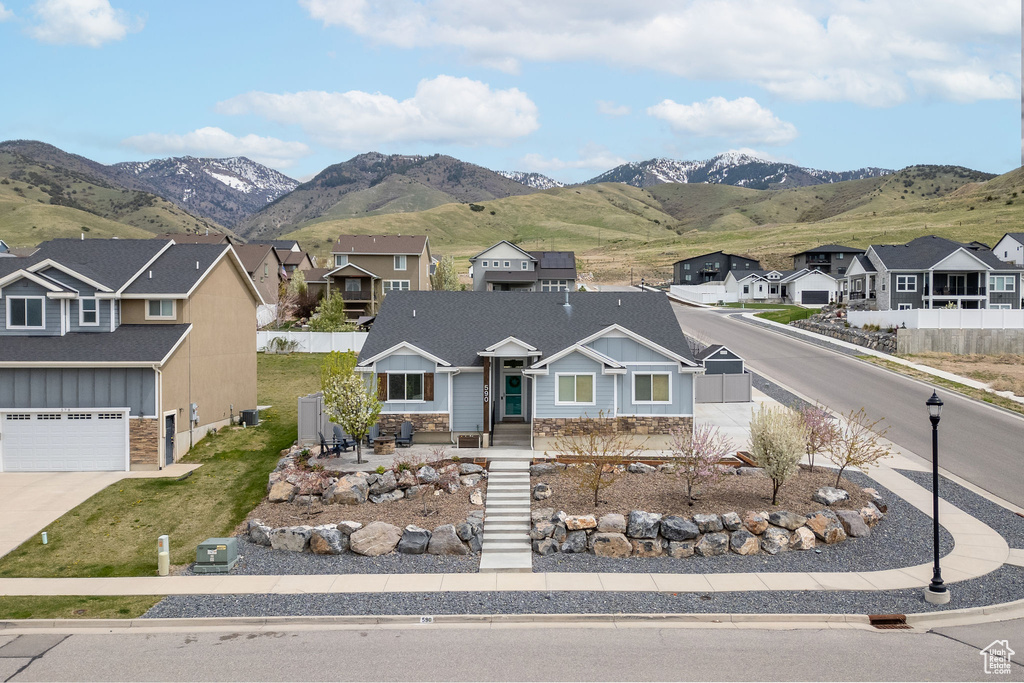 View of front of home with a residential view, fence, board and batten siding, and stone siding