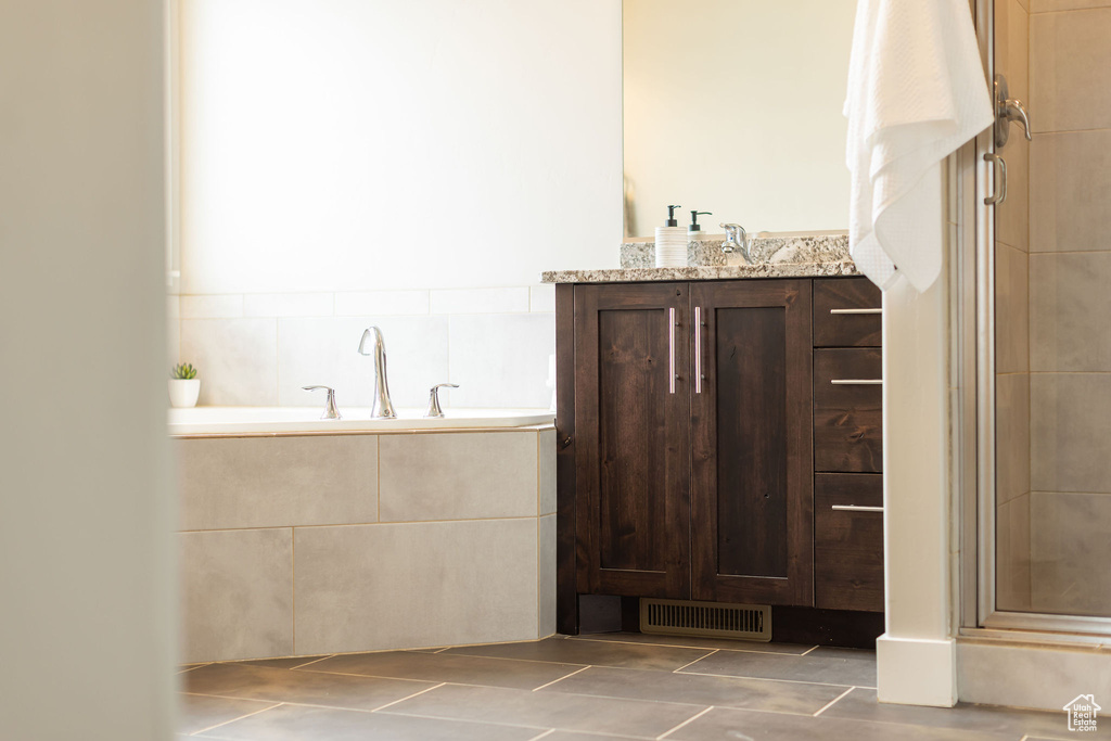 Full bathroom with vanity, tile patterned floors, a stall shower, and visible vents