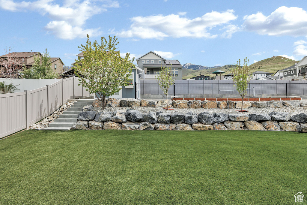 View of yard with stairs, a fenced backyard, and a residential view