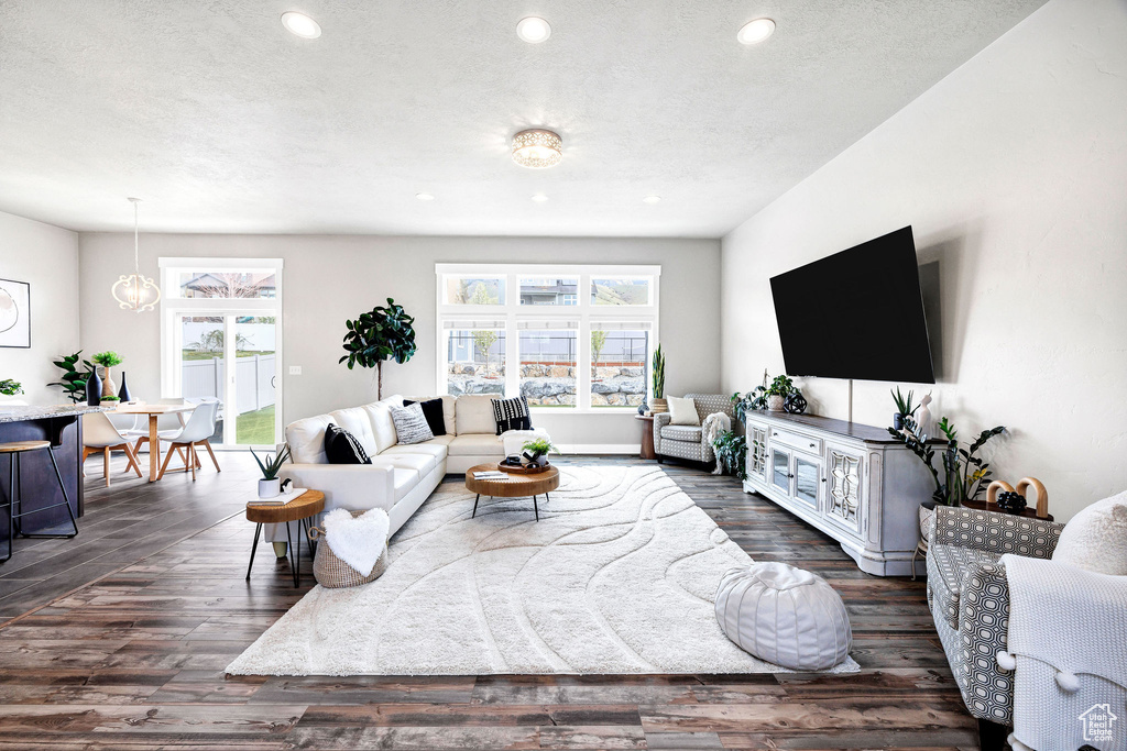 Living area with recessed lighting, dark wood finished floors, and a textured ceiling