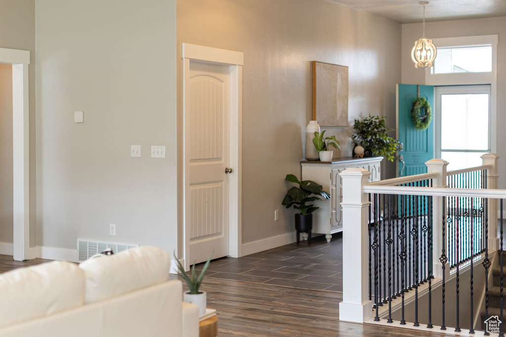 Interior space with baseboards, visible vents, wood finished floors, and a notable chandelier