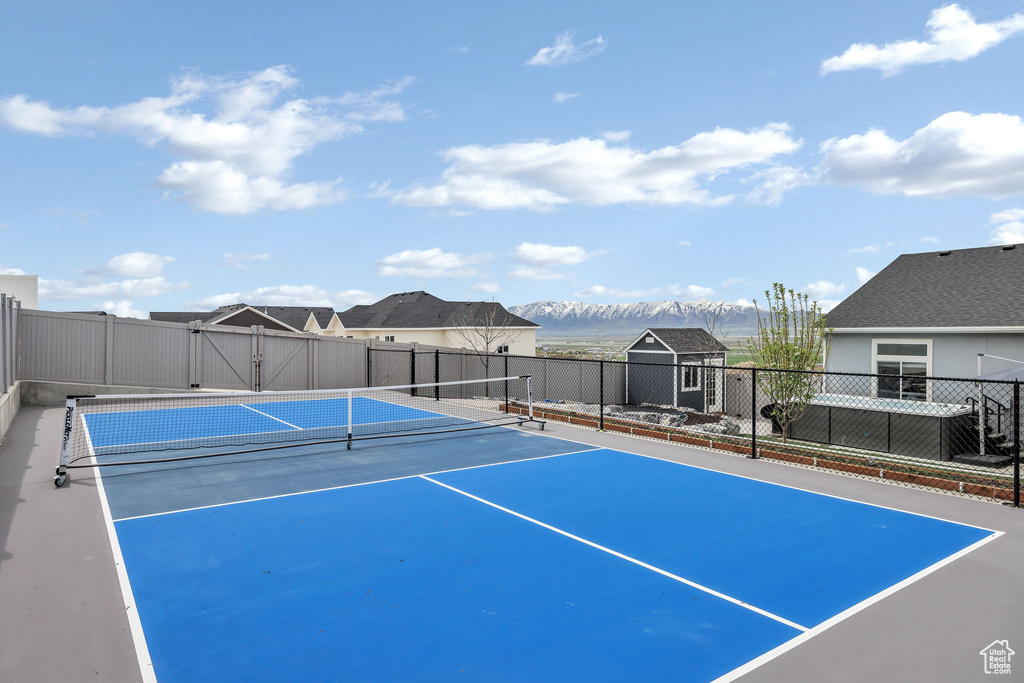 View of sport court featuring fence and a mountain view