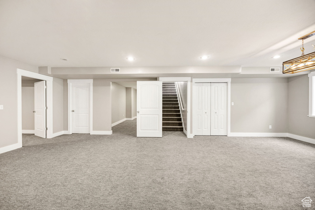 Finished basement with stairway, carpet floors, recessed lighting, and visible vents
