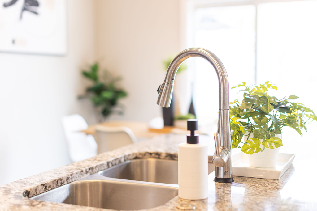 Details with a sink and light stone countertops