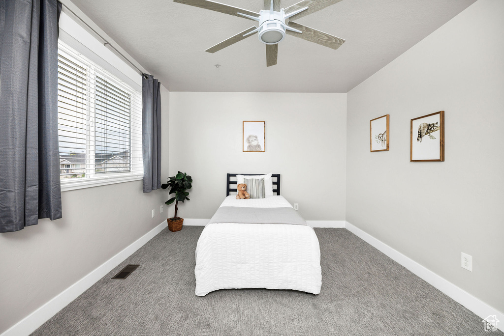 Carpeted bedroom with visible vents, baseboards, and ceiling fan