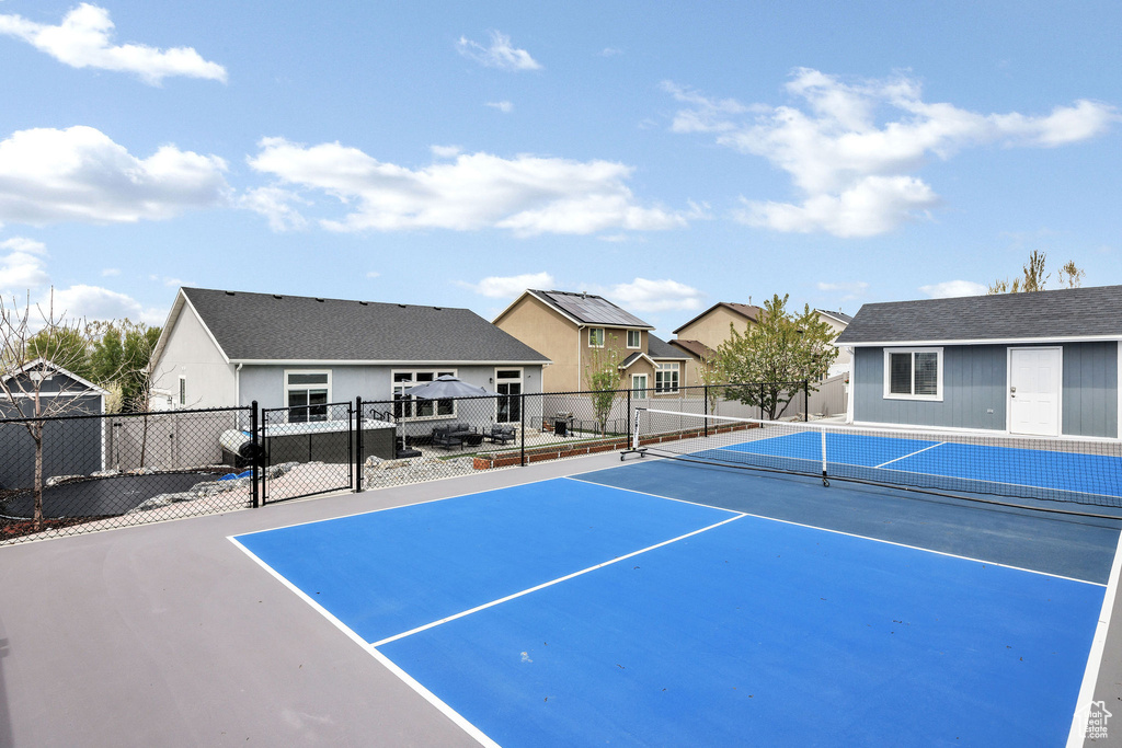 View of tennis court featuring fence and a residential view