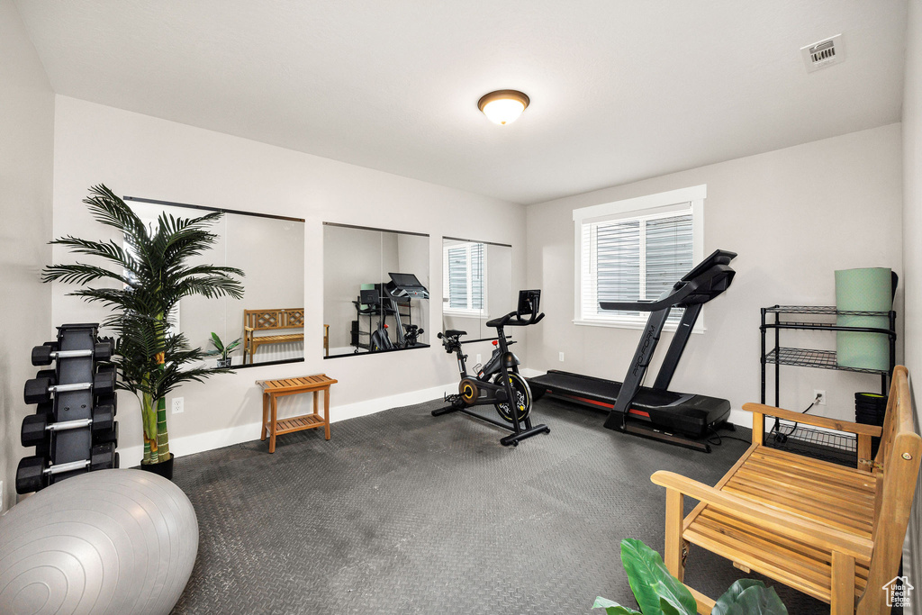 Exercise room with baseboards and visible vents