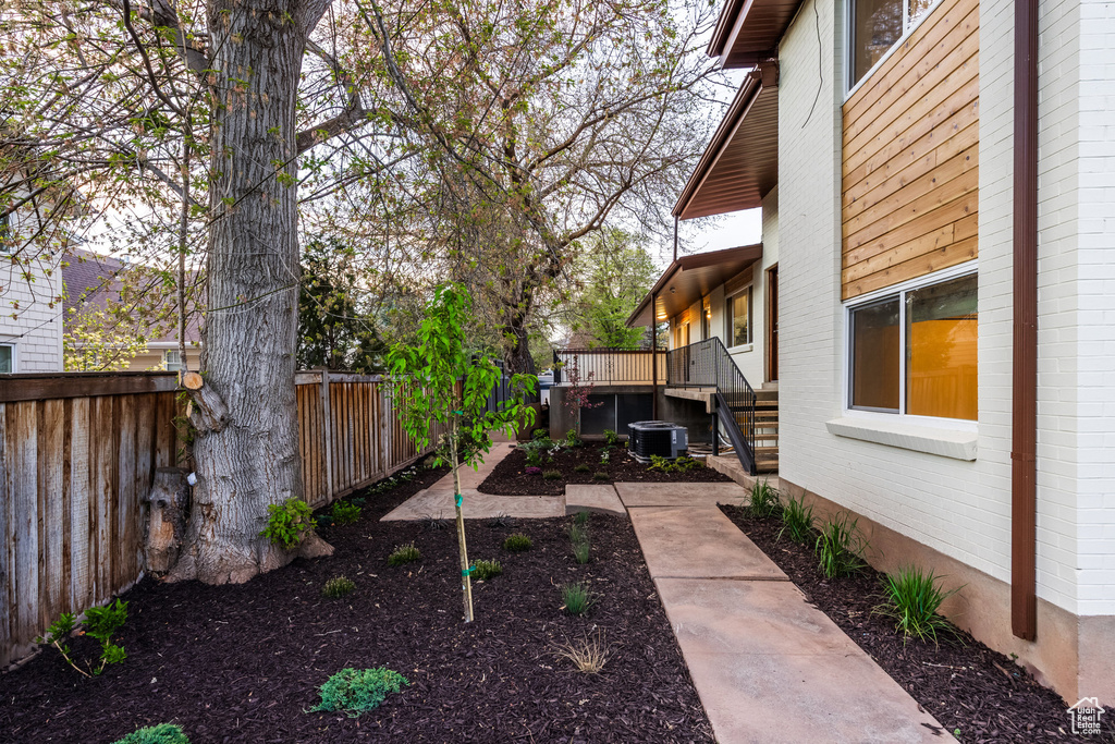 View of yard with a fenced backyard, central air condition unit, and a wooden deck