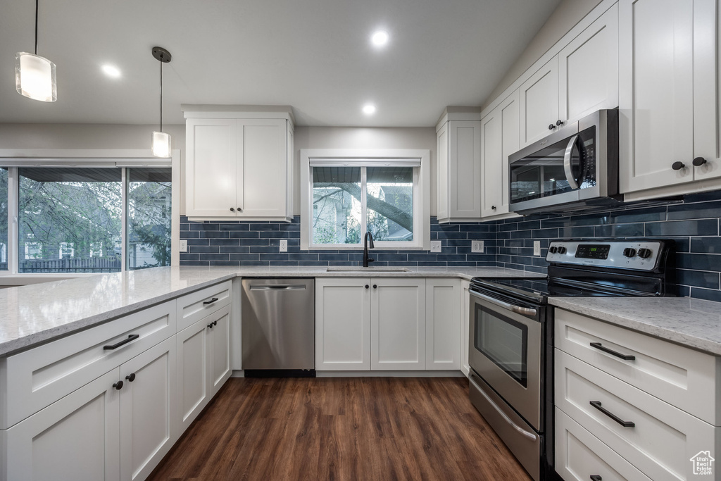 Kitchen with dark wood-style flooring, white cabinetry, appliances with stainless steel finishes, and a sink