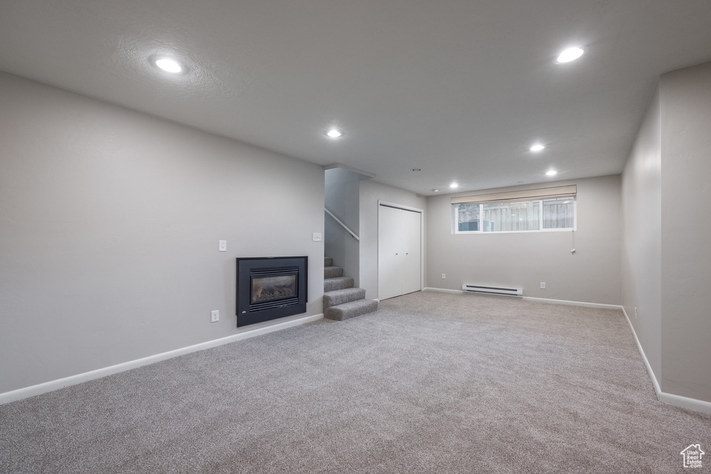 Below grade area with baseboards, light carpet, a baseboard heating unit, and recessed lighting