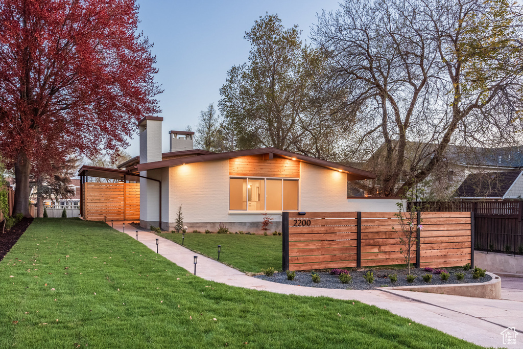 View of front facade featuring a fenced front yard, a chimney, and a front yard
