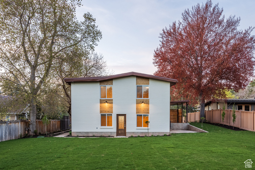 Rear view of house featuring a lawn, a fenced backyard, and a patio area