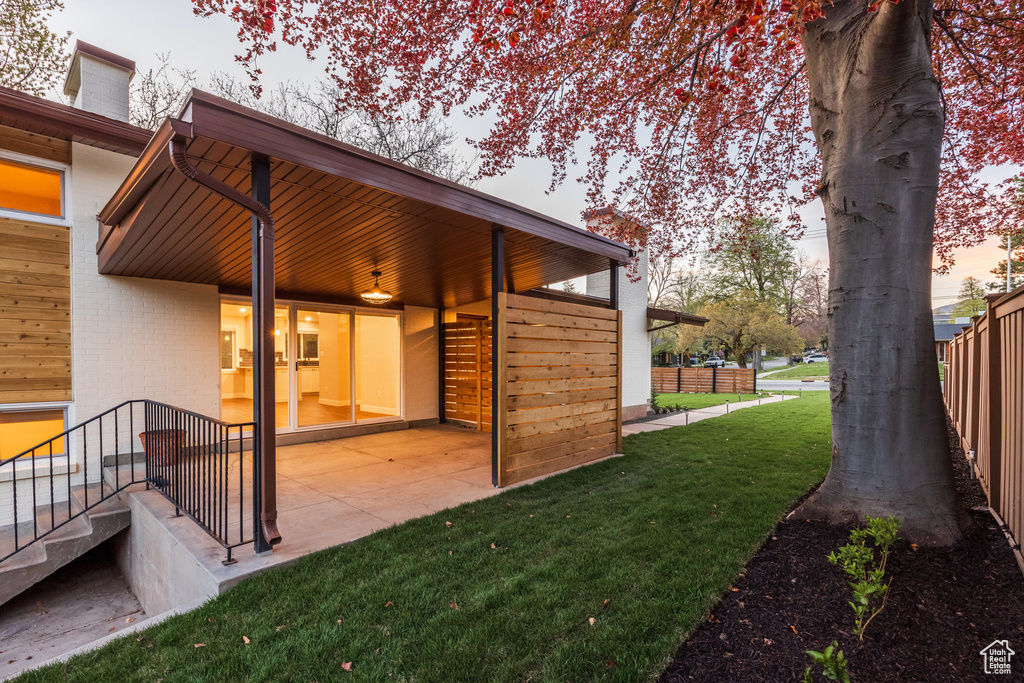 Exterior space featuring a lawn, a patio, and fence