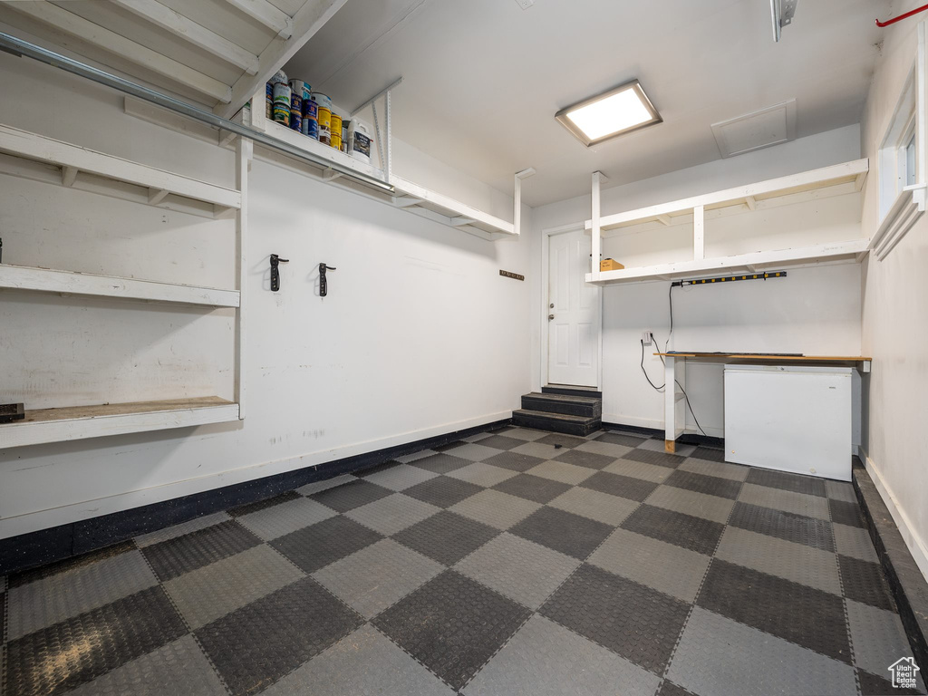 Garage featuring fridge and baseboards