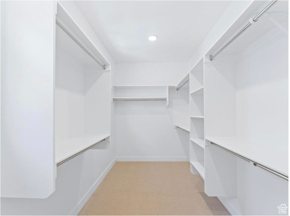 Walk in closet featuring light colored carpet