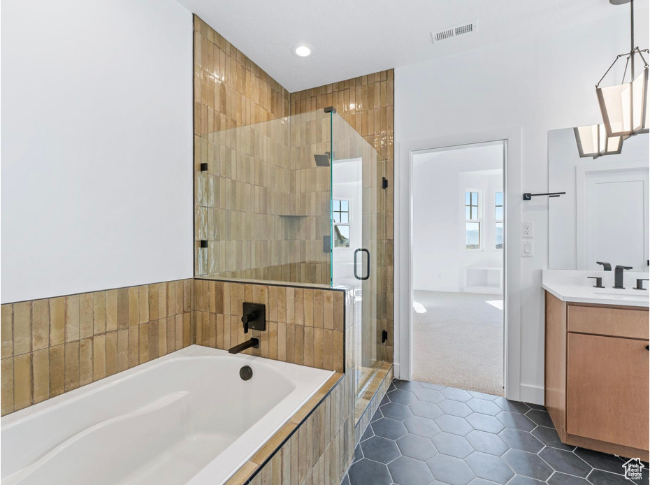 Bathroom featuring a bath, visible vents, tile patterned flooring, a shower stall, and vanity
