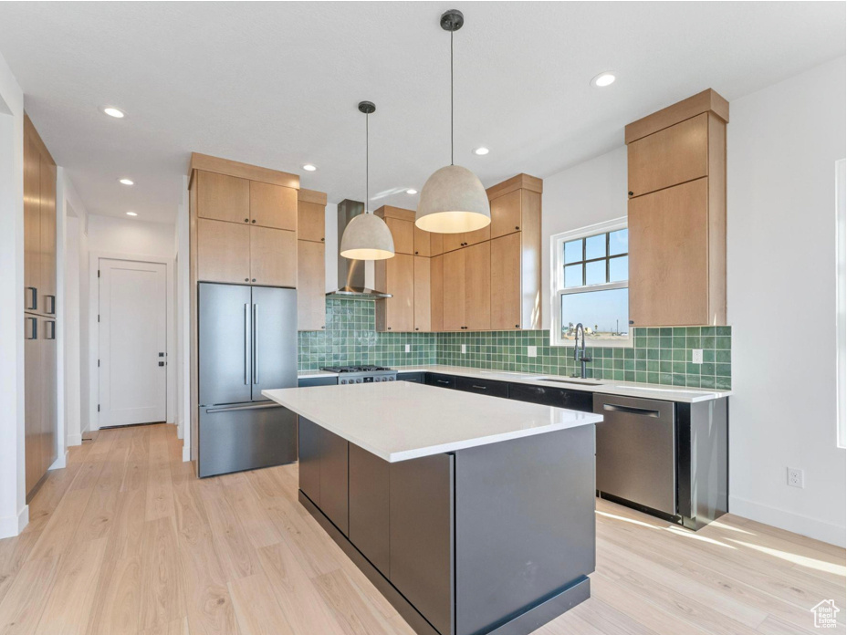 Kitchen featuring a sink, light wood finished floors, appliances with stainless steel finishes, and light countertops