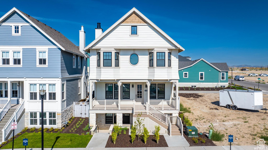 View of front of house with covered porch, stairs, and stone siding
