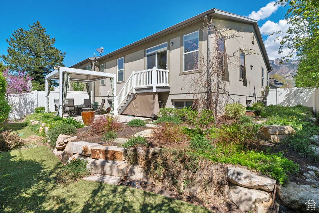 Back of house with a patio, a fenced backyard, a lawn, and stairway