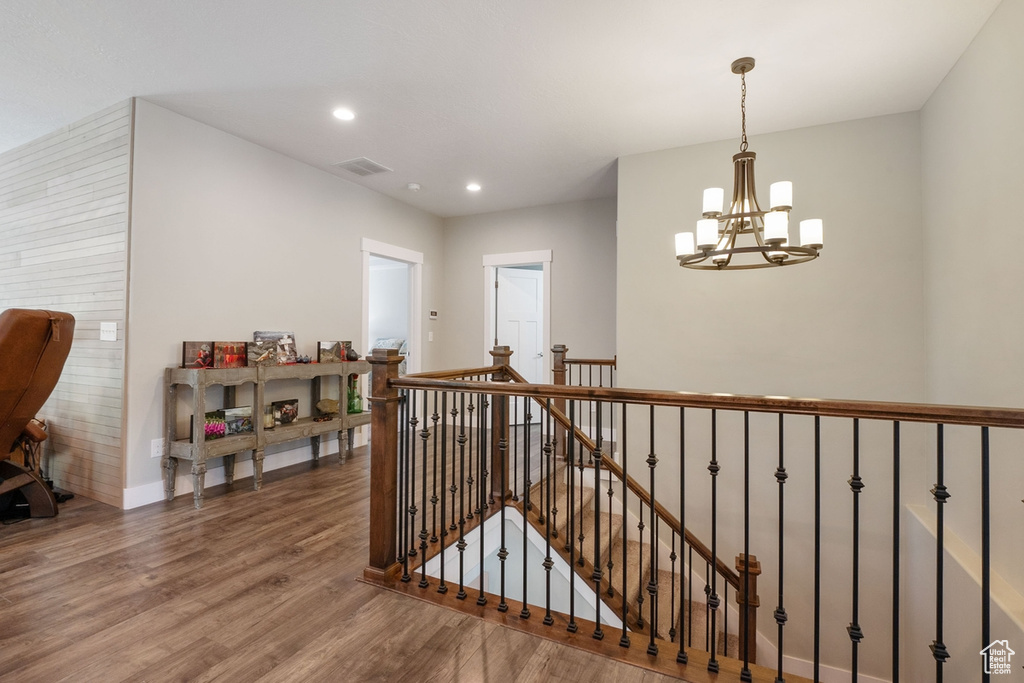 Staircase featuring visible vents, wood finished floors, baseboards, recessed lighting, and a chandelier