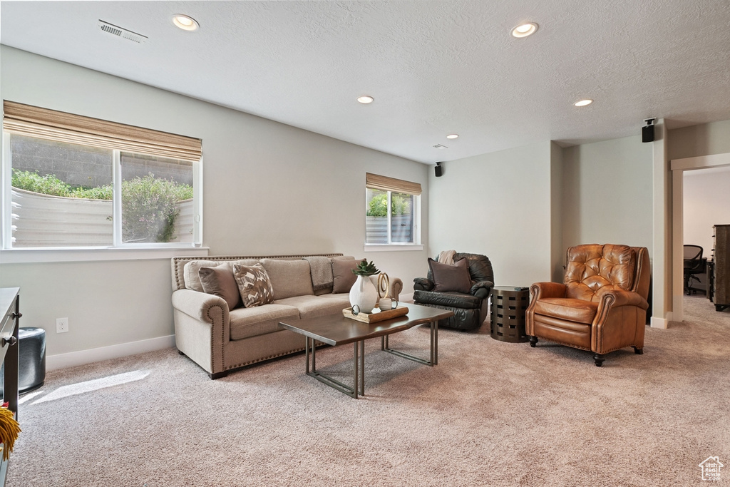 Living area with recessed lighting, baseboards, visible vents, and light carpet