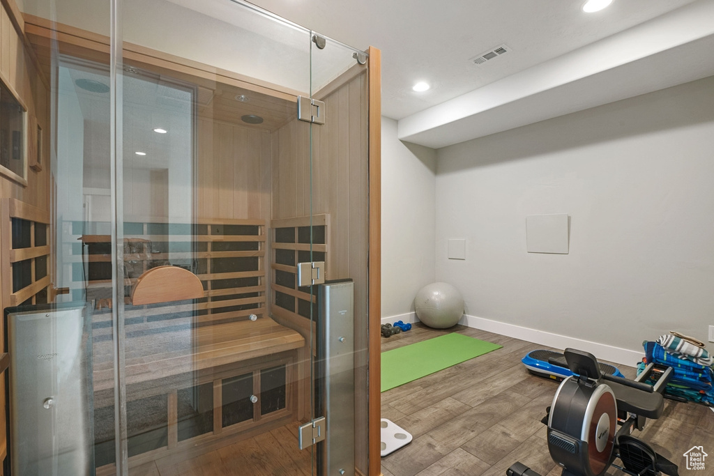 Workout room featuring a sauna, recessed lighting, wood finished floors, and visible vents