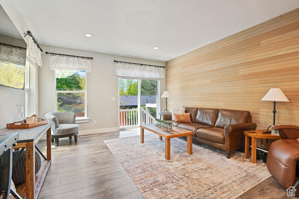 Living area with recessed lighting, wood walls, and wood finished floors