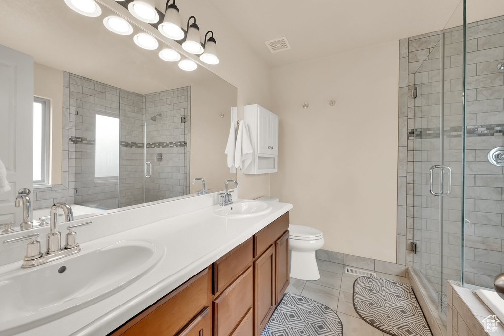 Bathroom with a sink, tile patterned floors, and tiled shower