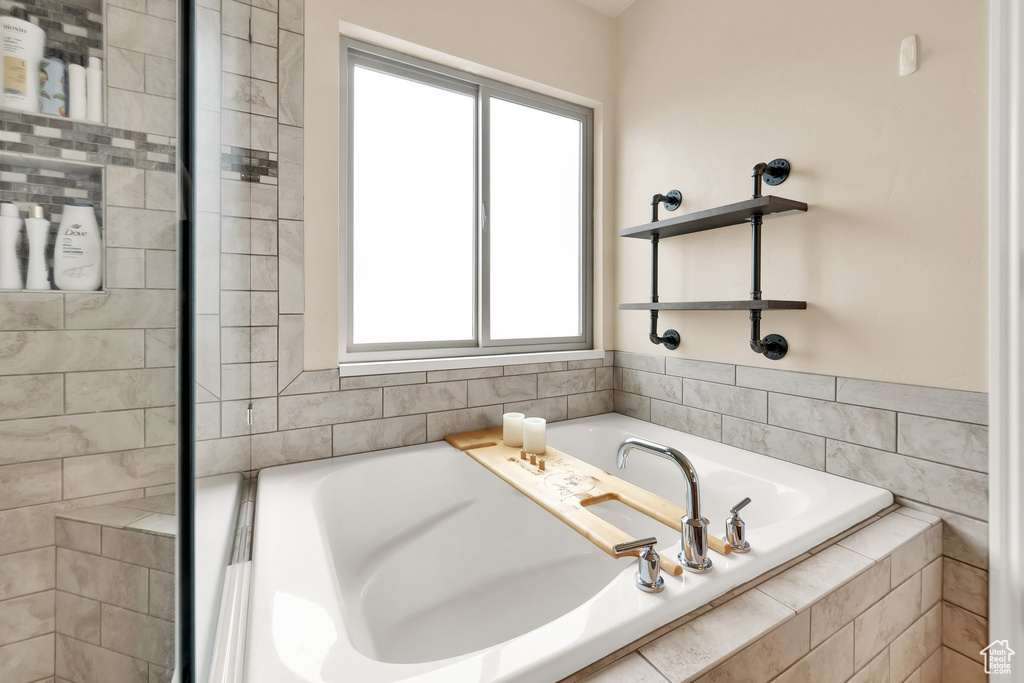 Full bath with a healthy amount of sunlight and a bath