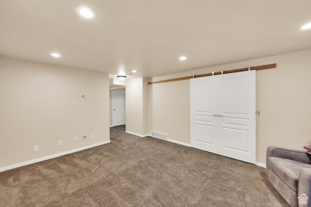 Finished basement with carpet floors, baseboards, recessed lighting, and visible vents
